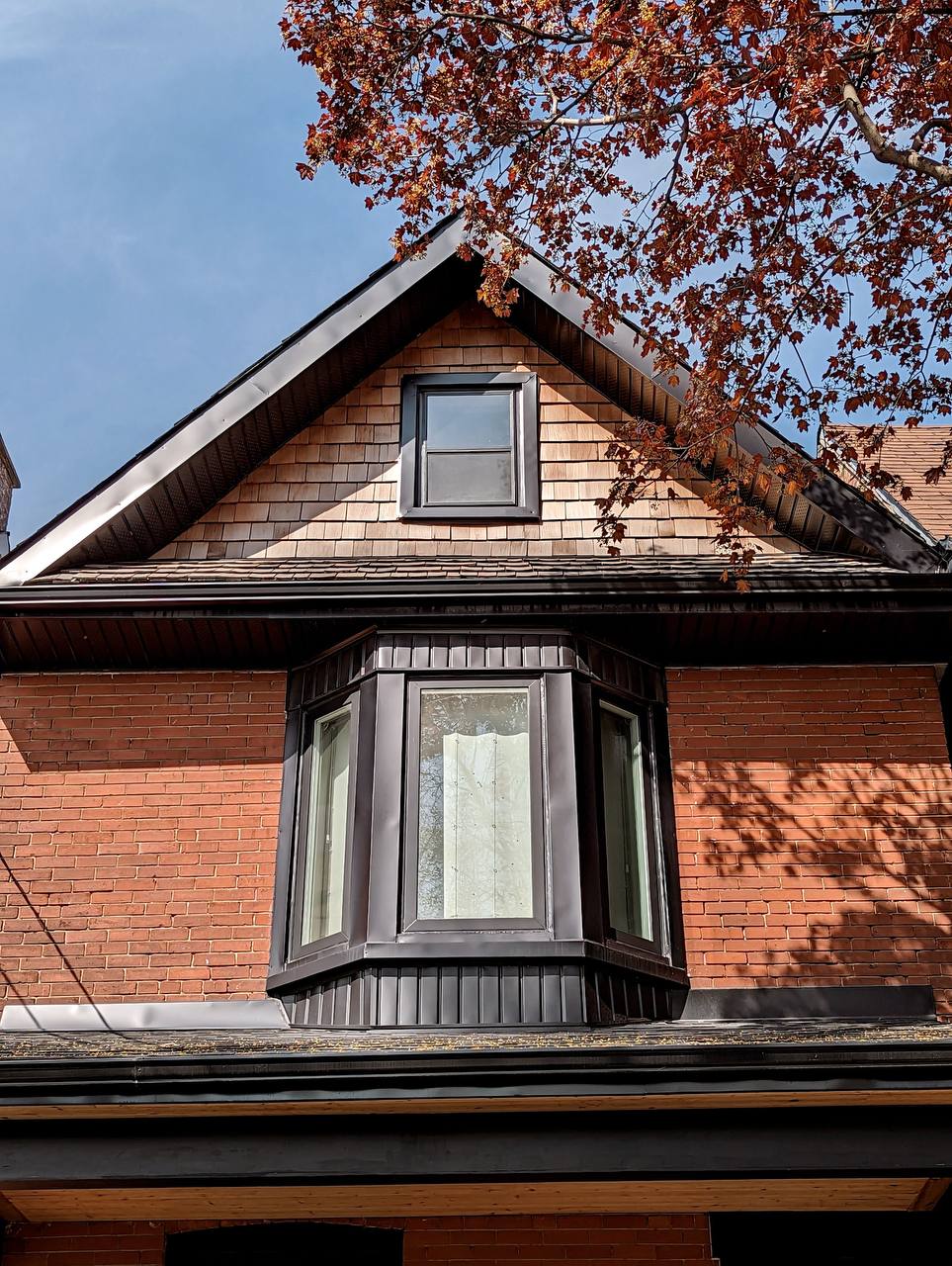 Newly painted black vinyl windows in Toronto with Full Stix primer and Benjamin Moore exterior Aura paint in soft-gloss finish, showcasing two windows with a sleek, modern finish.