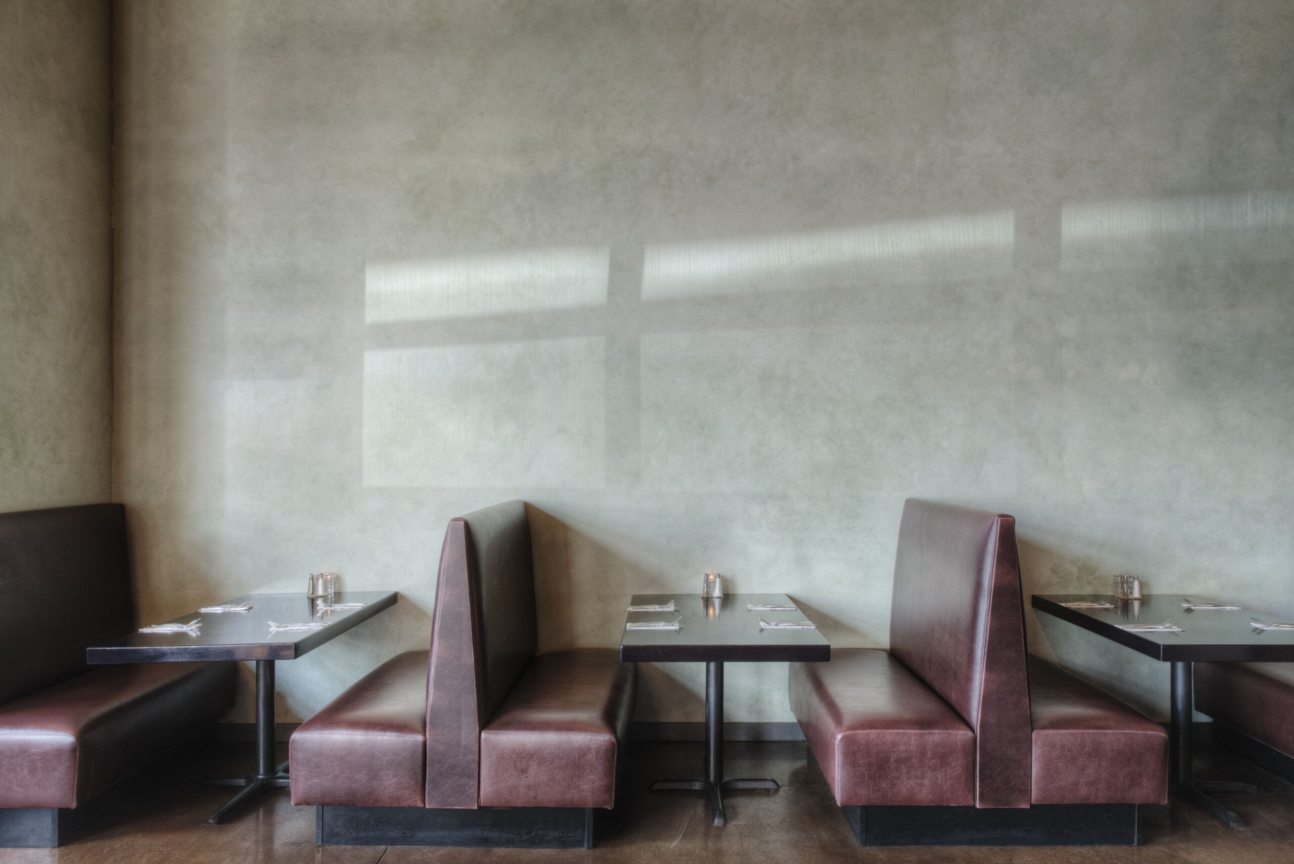 Empty restaurant featuring Venetian plaster walls with a greige undertone in Toronto.