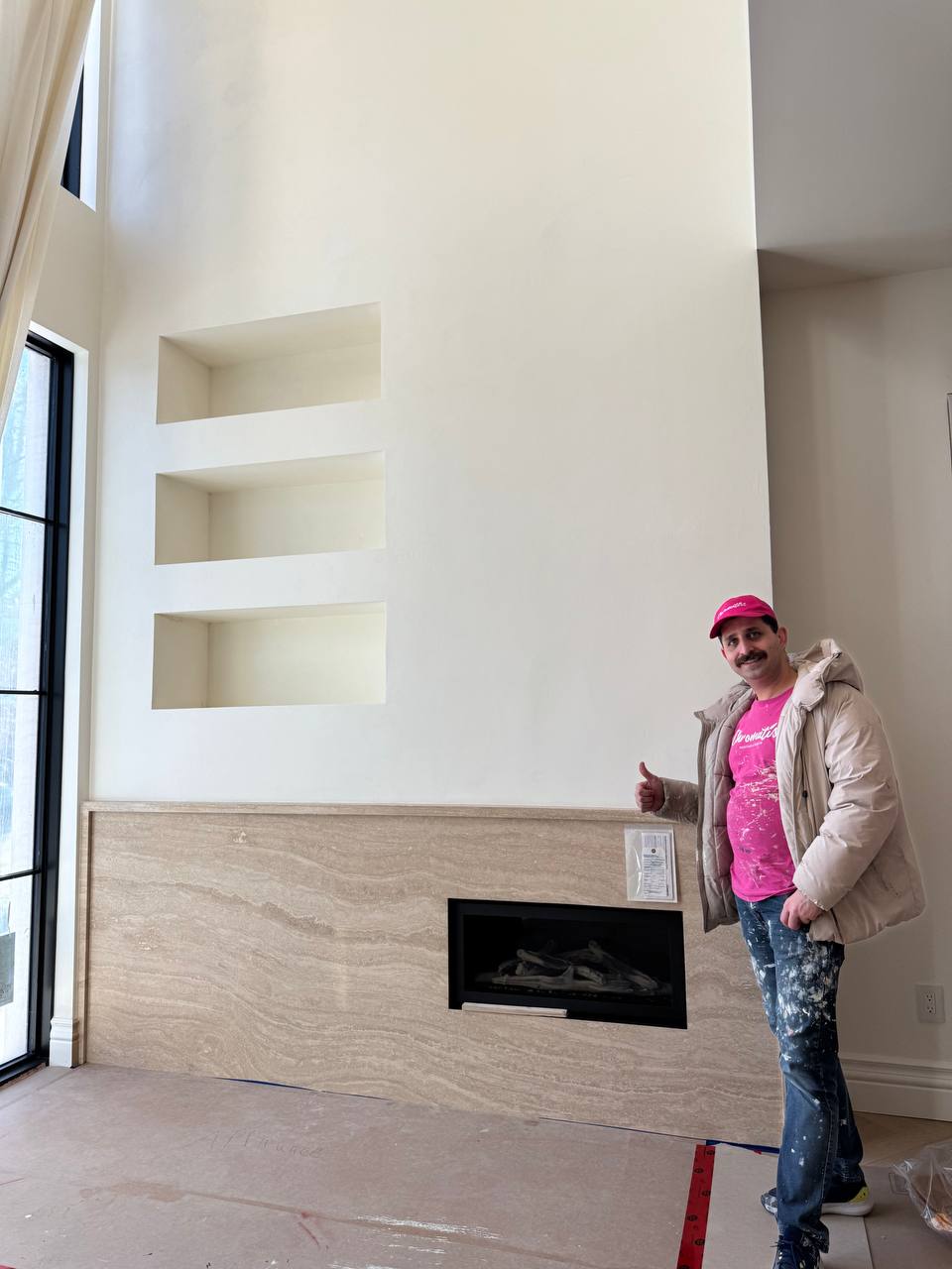 A grand fireplace wall finished in Venetian plaster with the owner of Chromatist standing beside it in a luxury home in Rosedale, Toronto 2025.