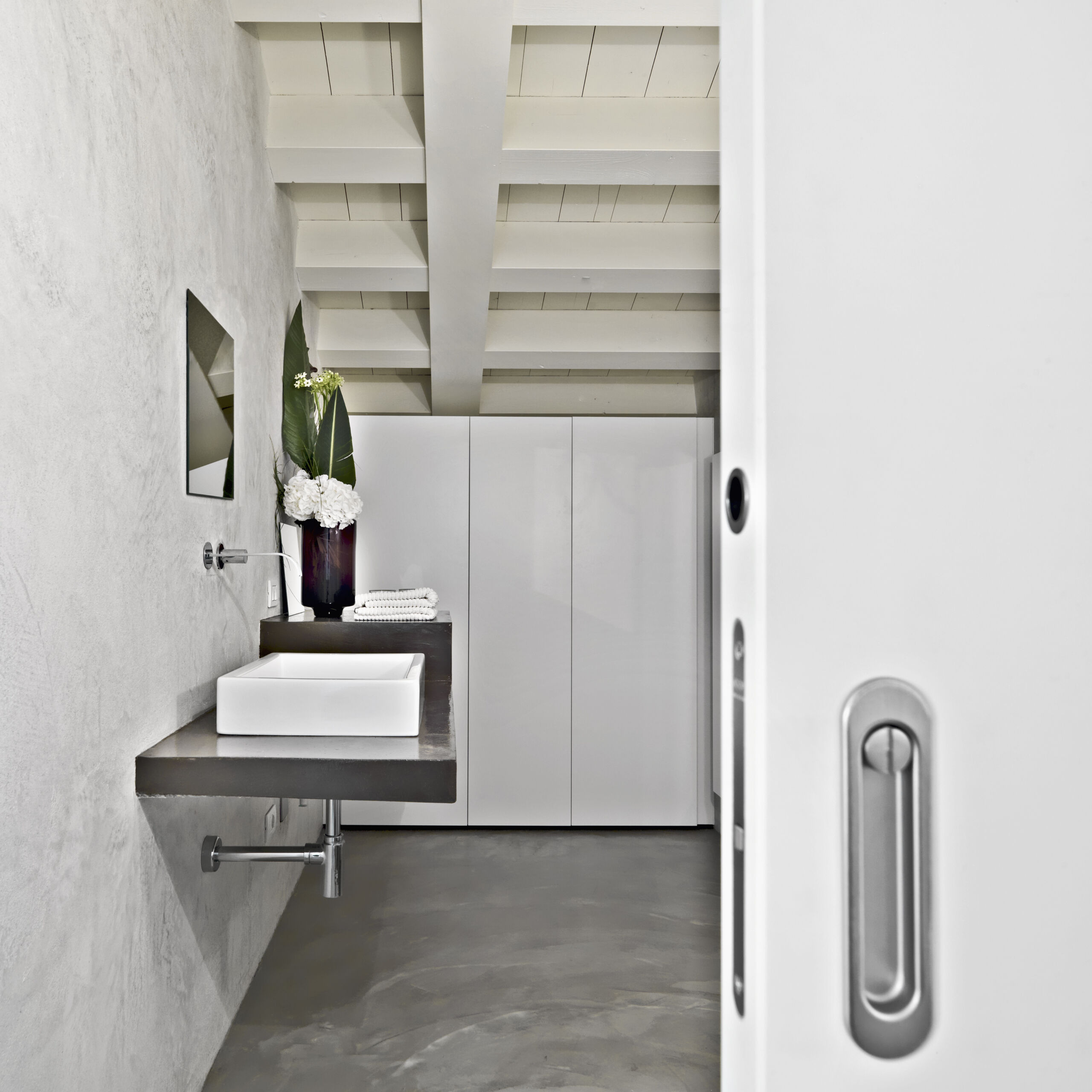 Modern bathroom interior in The Beaches, Toronto, featuring sleek microcement flooring and a matching vanity, creating a cohesive and contemporary design.