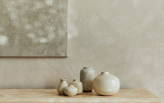 Earthy tone limewash paint on a living room wall behind a buffet, showcasing a warm, textured finish that adds depth and character to the space.