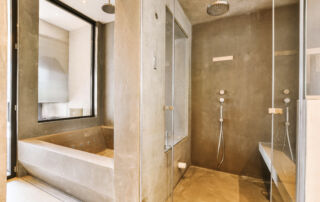 Microcement finish in a bathroom with walls and floors, including a shower box, highlighting a seamless and modern design in a cottage in kawartha