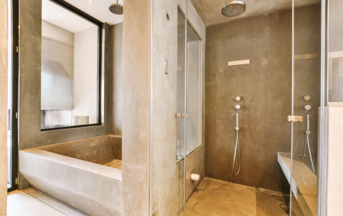 Microcement finish in a bathroom with walls and floors, including a shower box, highlighting a seamless and modern design in a cottage in kawartha