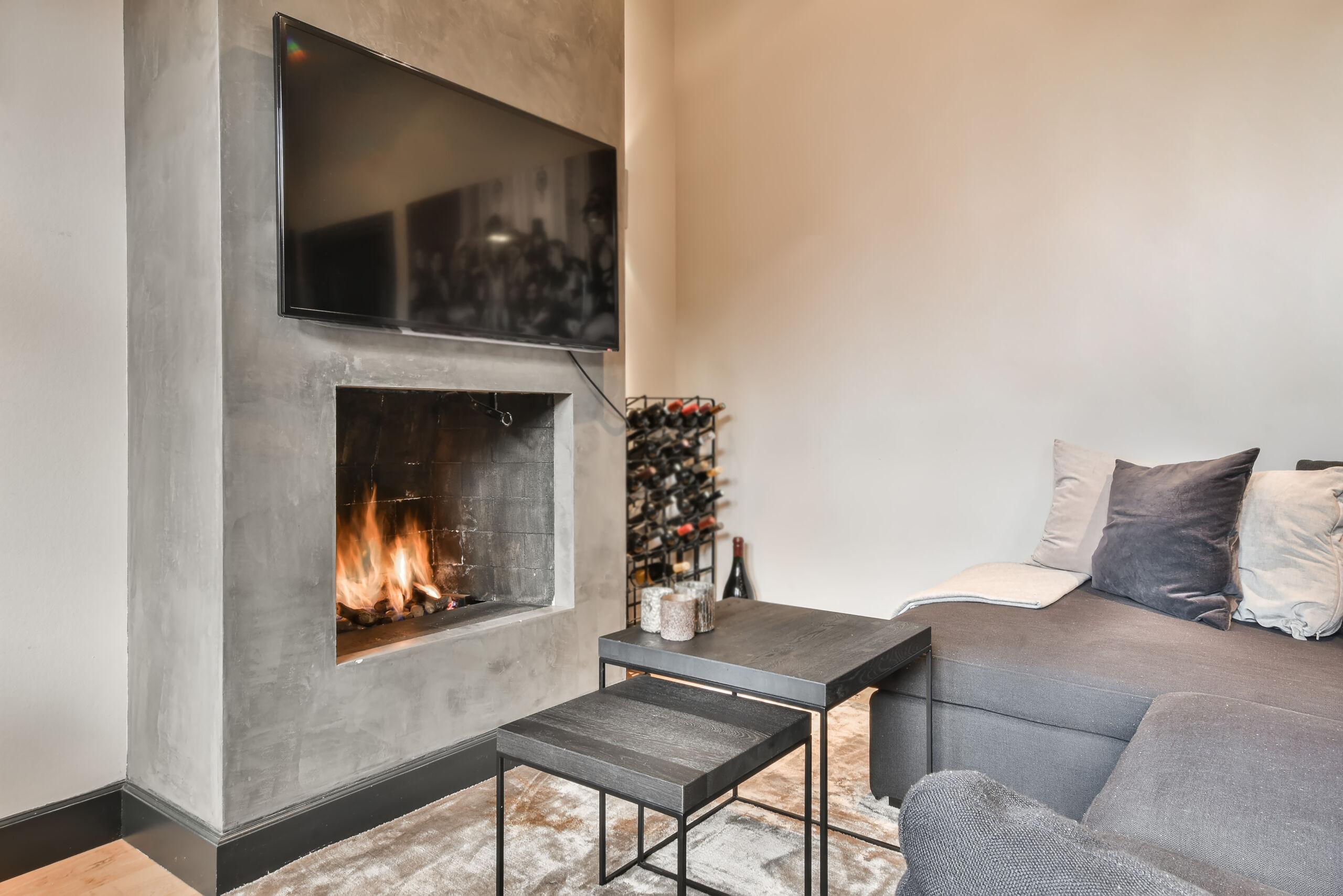 A modern fireplace wall finish in microcement with a smooth, minimalist design, showcasing a seamless blend of textures in a contemporary Toronto living room.