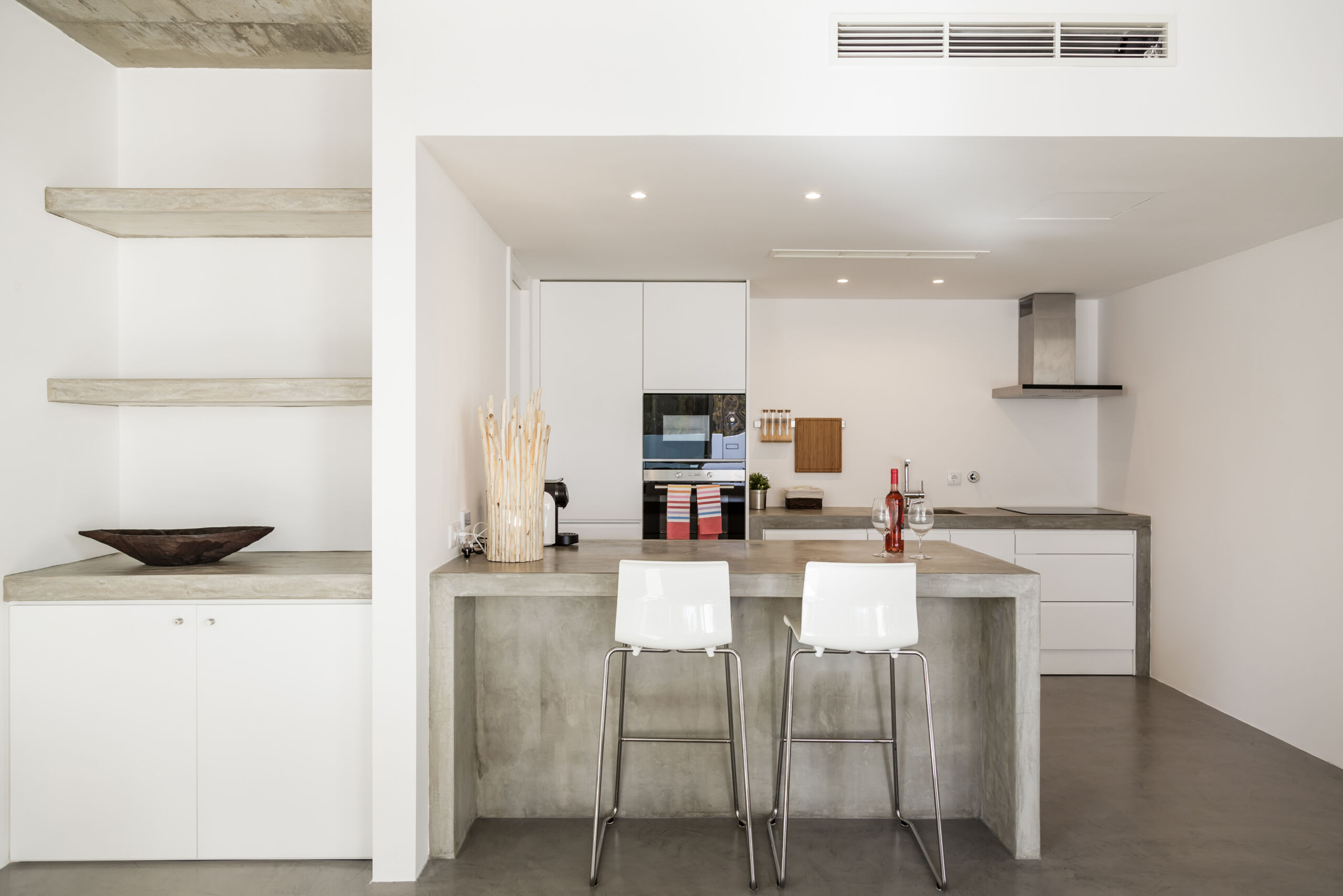 Modern kitchen with a sleek microcement island in a Toronto house, showcasing a contemporary and durable finish.