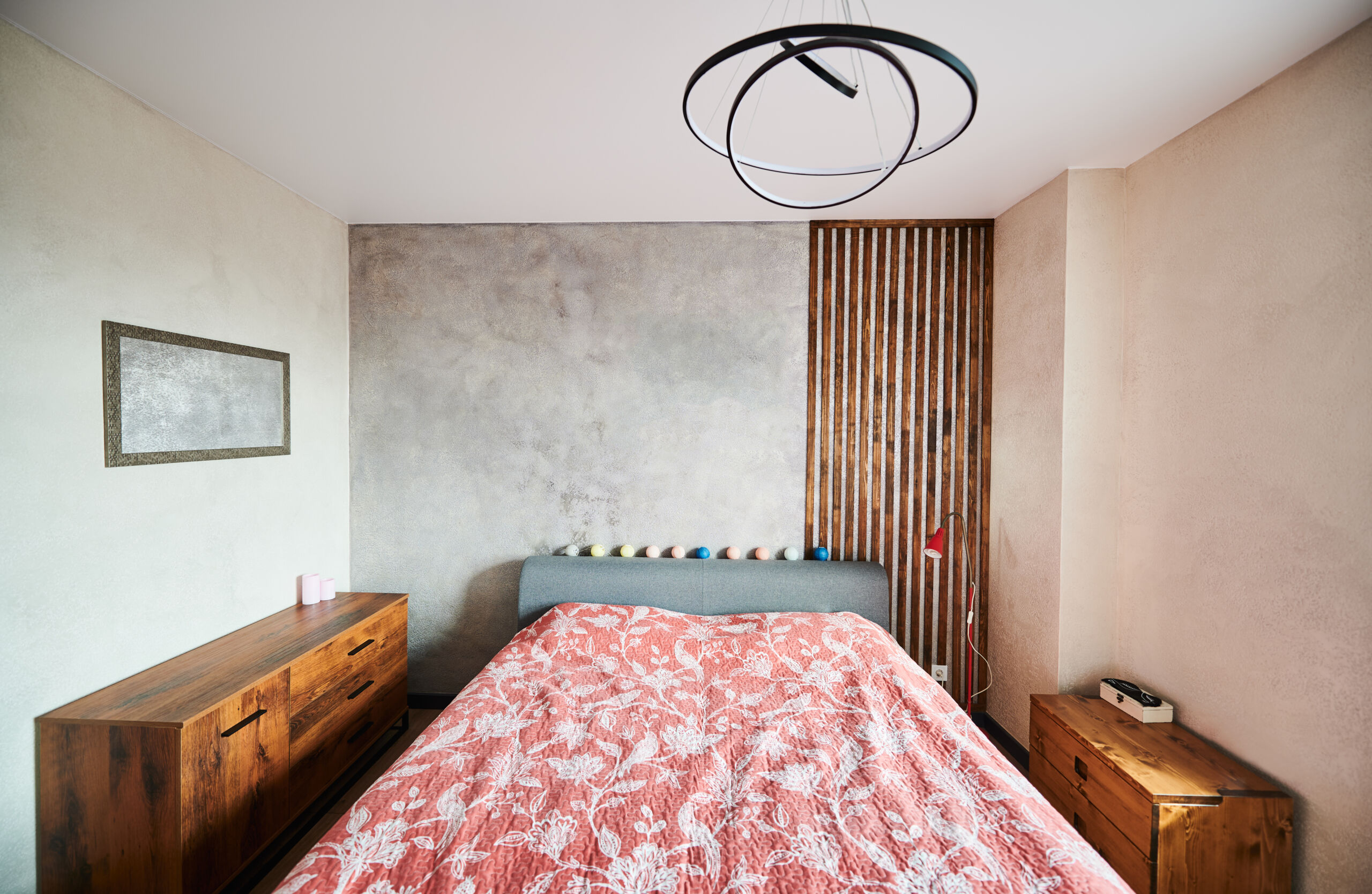 Textured wall for bedroom with Venetian plaster combined with natural wood panels in a modern interior.