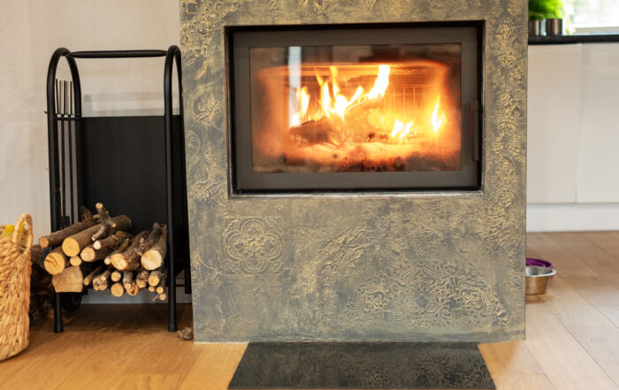 Fireplace accent wall finished in two-tone Venetian plaster, showcasing a luxurious, textured finish in a modern living room.