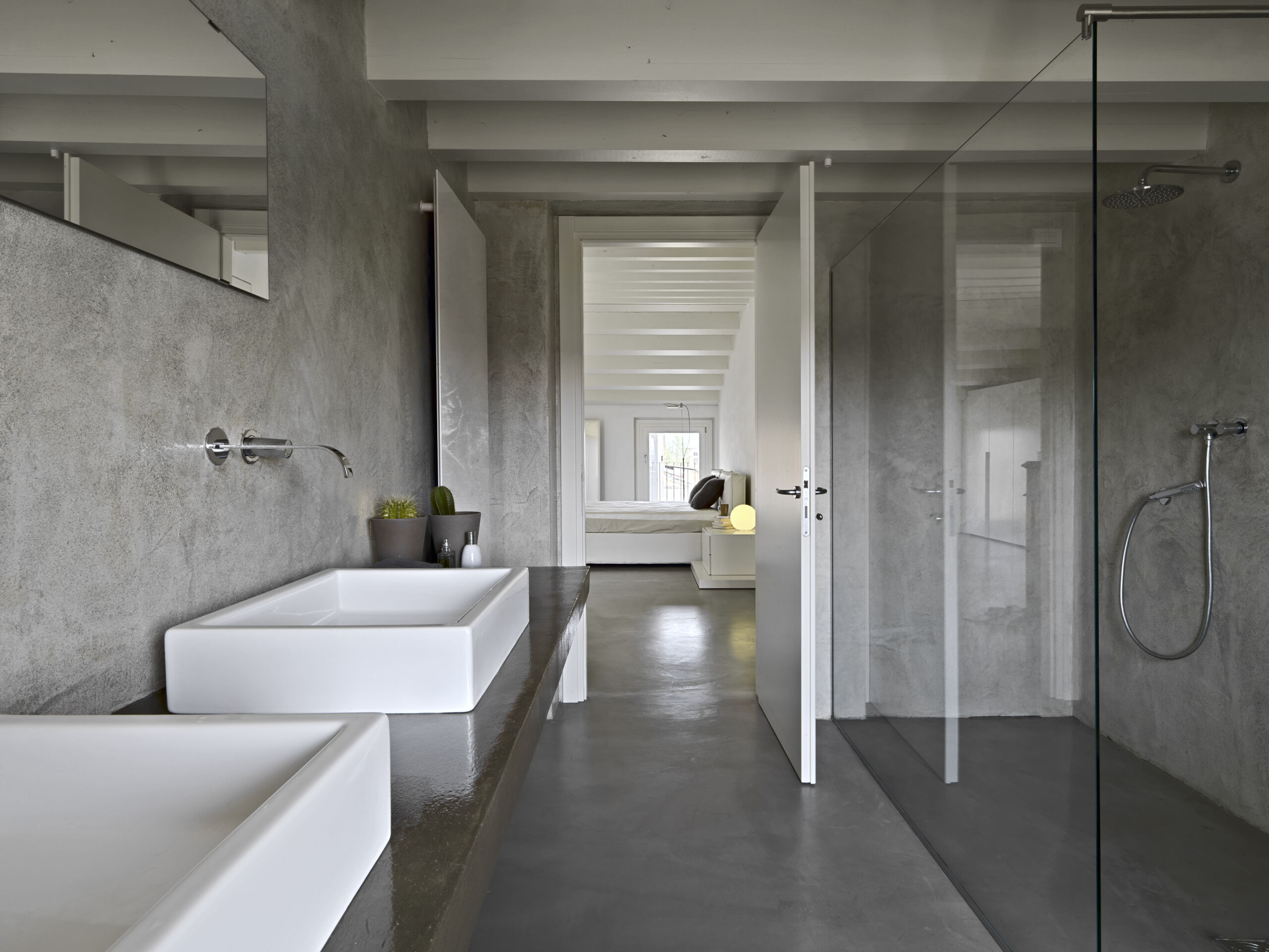 Modern en-suite bathroom with walls and floors finished in microcement, giving a sleek, contemporary look