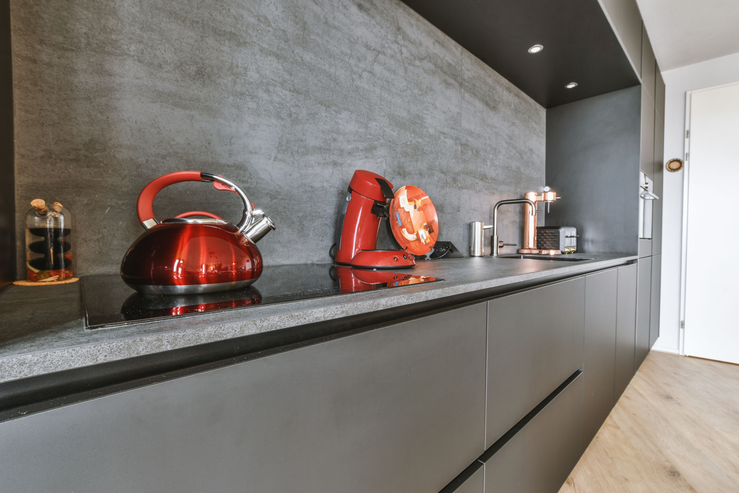 Small kitchen interior with micro concrete wall finish over the backsplash and counter area.