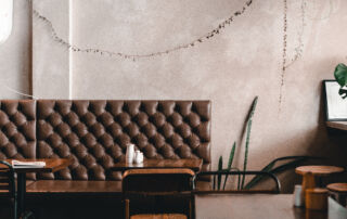 Cafe interior wall finished with microcement in beige grey colour.