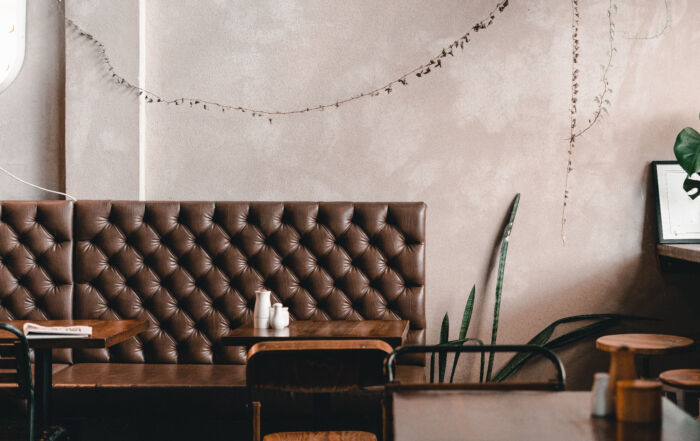 Cafe interior wall finished with microcement in beige grey colour.