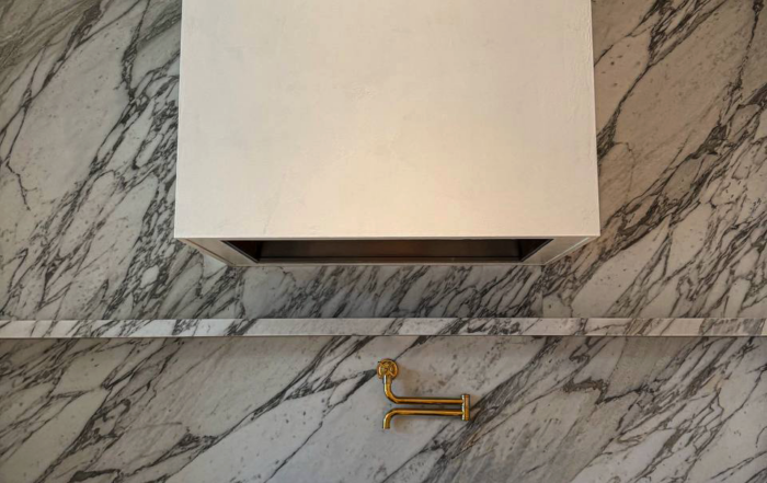 A Venetian plaster range hood in warm off-white, adding depth, texture, and timeless elegance to a luxury kitchen in Rosedale, Toronto.